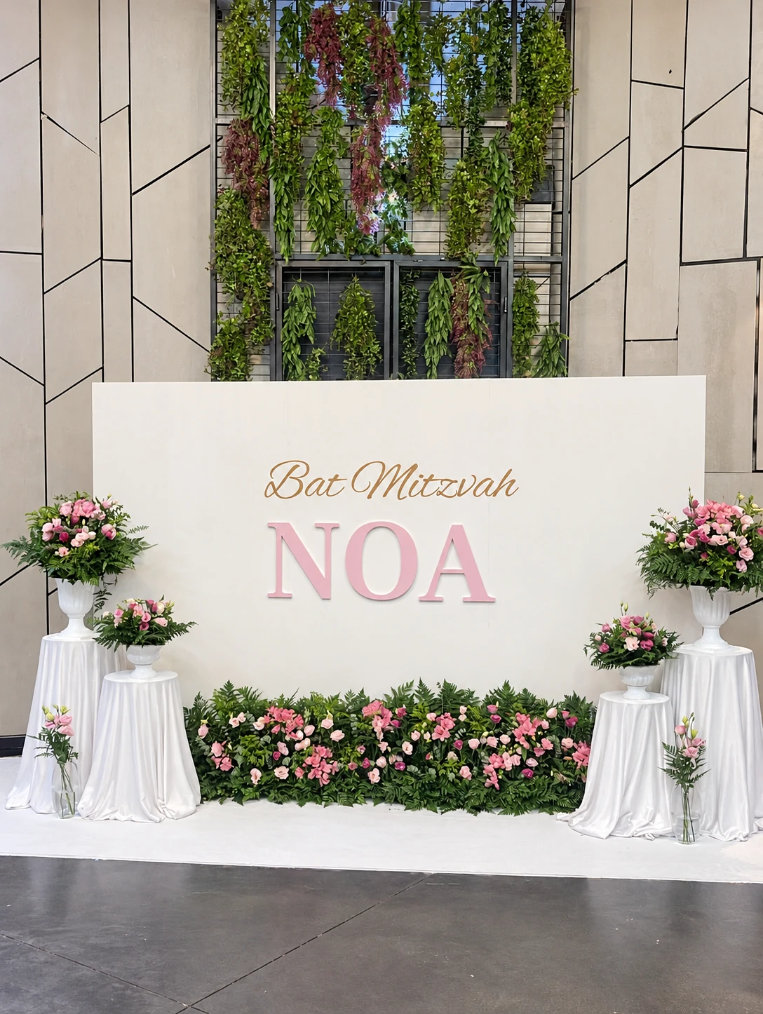 קיר בת המצווה של NOA עם פרחים ורודים — צילום בעריכת צבע ותאורה