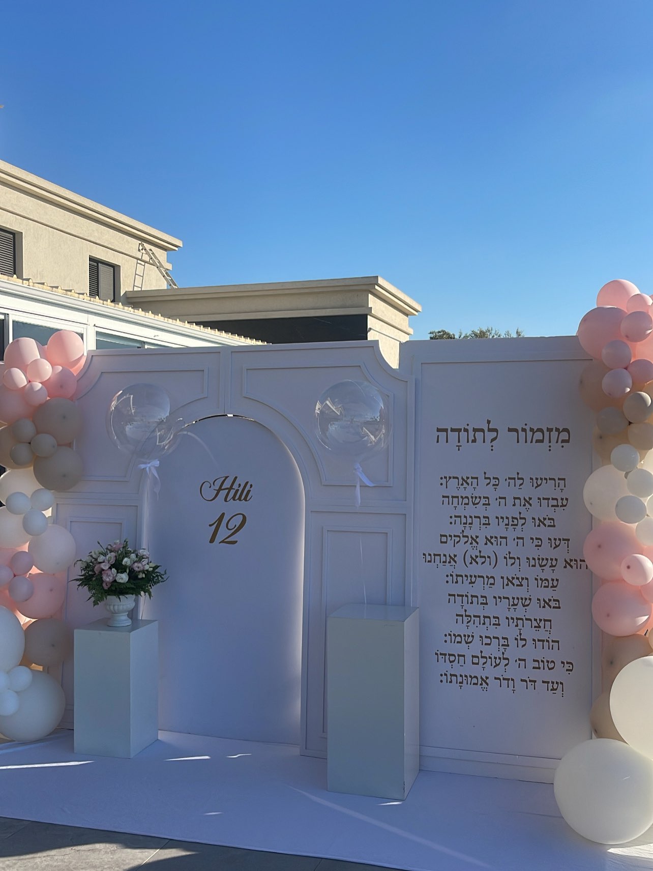 קיר צילום לבת מצווה בגוני לבן וורוד בחצר